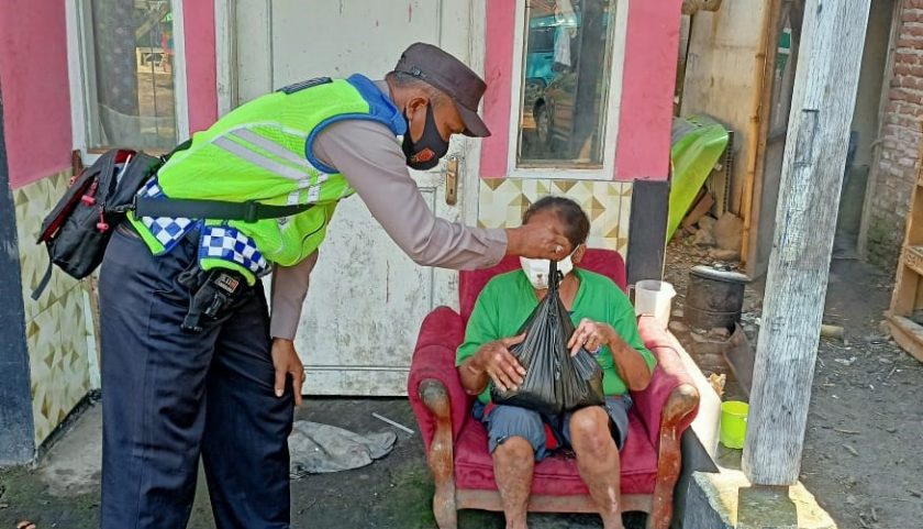Bhabinkamtibmas Polsek Cangkuang saat membagikan sembako kepada warga