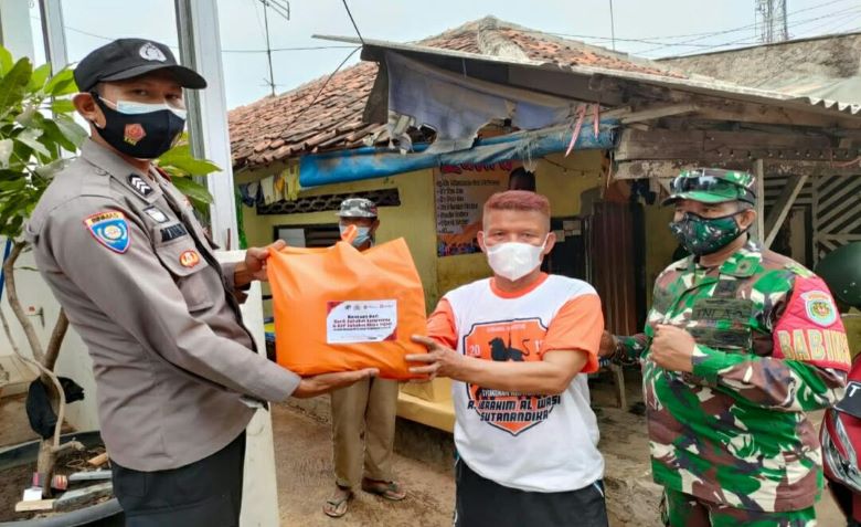 Personel Polres Subang saat membagikan sembako kepada warga terdampak PPKM.