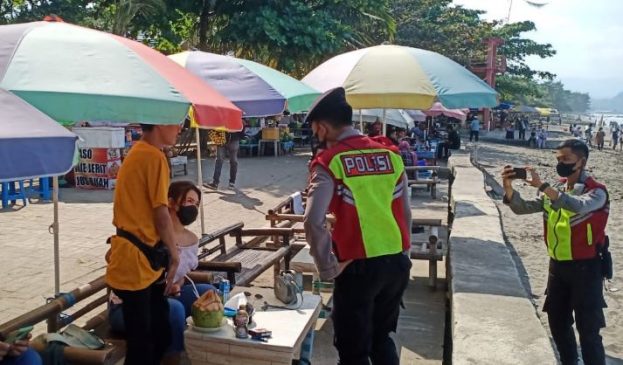 Polisi Hampiri Wisatawan di Pantai, Ingatkan Prokes dan Bagikan Masker di Masa PPKM