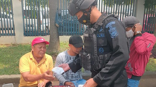 Tekan Penyebaran Covid-19, Personel Sat Brimob Polda Jabar Laksanakan Pembagian Masker Gratis di Masa PPKM