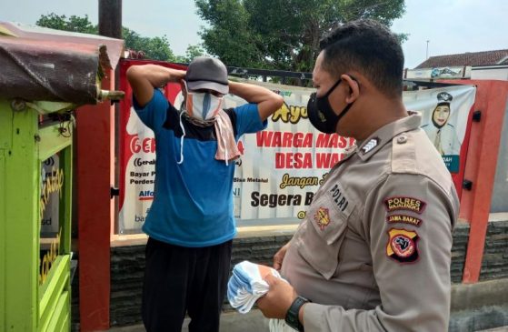 Cegah Penyebaran Covid-19, Polisi Bagikan Masker kepada Masyarakat di Masa PPKM