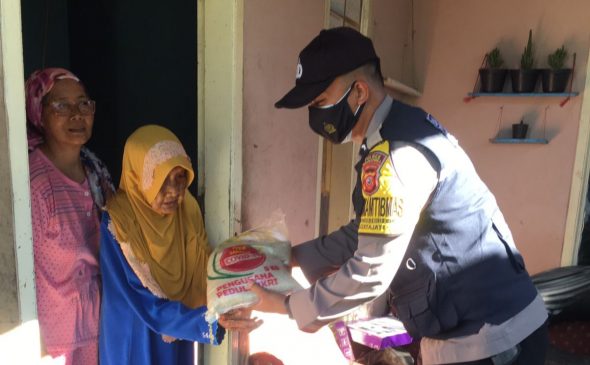 Polisi Bagikan Masker dan Bansos Beras Secara Door to Door Kepada Warga