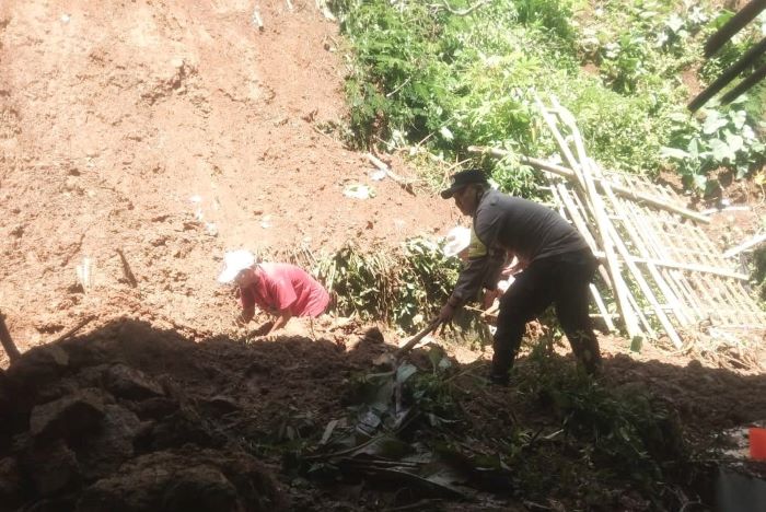 Polisi Bantu Warga Bersihkan Material Tanah Longsor yang Menutupi Jalan
