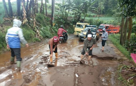 Polisi Bersihkan Tumpukan Lumpur yang Menutupi Jalan Raya Cibeureum
