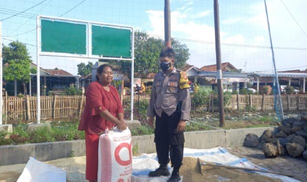 Polisi Bantu Warga Masukkan Padi ke Dalam Karung Saat Hujan Gerimis