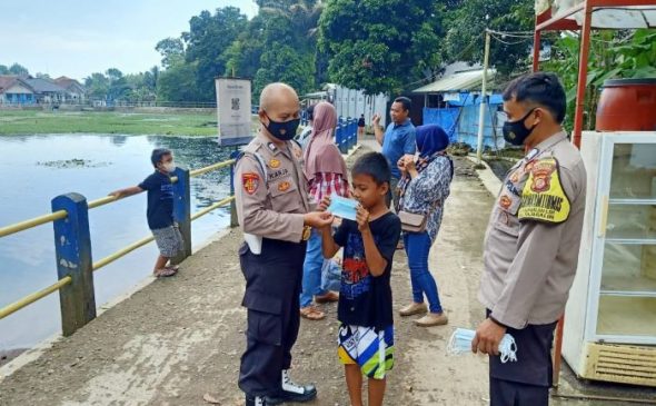 Patroli Wisata, Polisi Edukasi Masyarakat dengan Bagikan Masker di Obyek Wisata Situ Janawi