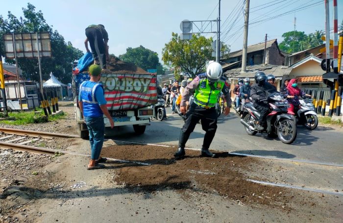 Polisi Tambal Jalan Berlubang di Perlintasan Rel Kereta Api Cipeuyeum