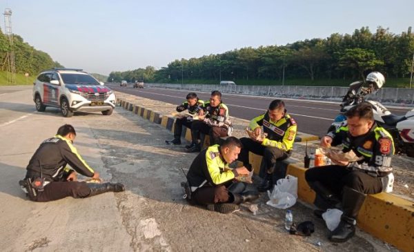 Polisi Tugas di Momen Lebaran, Makan Nasi Bungkus di Pinggir Jalan