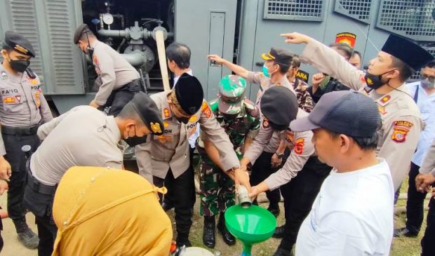 Polisi Bagikan Air Bersih Kepada Warga Cikandang yang Membutuhkan dengan Rantis Water Cannon