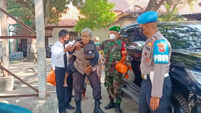 Tanpa Ragu, Polisi Gendong Lansia Antri Bansos Sembako di Cirebon Kota
