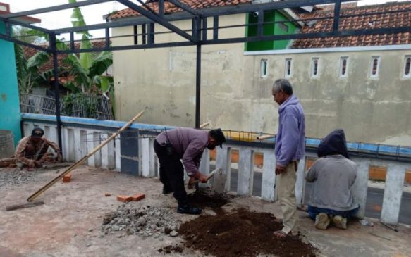 Polisi Bantu Kerja Warga Bangun Tempat Parkir di Halaman Balai Desa Kalapagunung