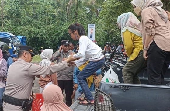 Anggota Polri Bantu Angkut Warga ke Lokasi Objek Wisata Situ Cipanten