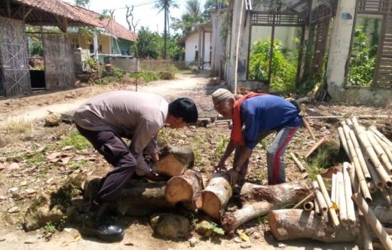Bhabinkamtibmas dengan CAKEP Bantu Lansia yang Angkut Kayu Berat