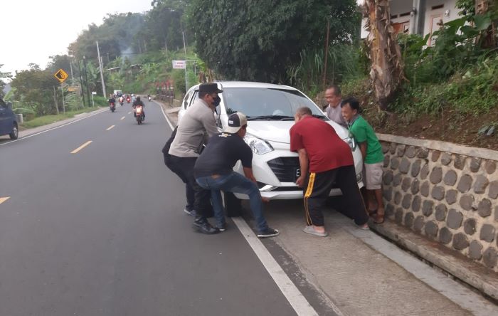 Sigap, Polisi Bantu Angkat Mobil yang Terperosok ke Saluran Air di Jalan Raya Cirandang Kuningan