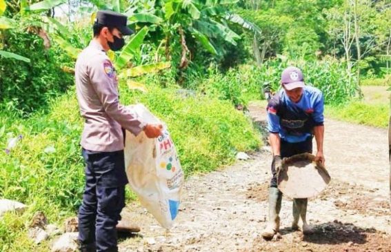 Polisi dan Masyarakat Kerja Bakti Perbaiki Jalan Berlubang dan Bersihkan Rumput di Jalur Jalan Desa